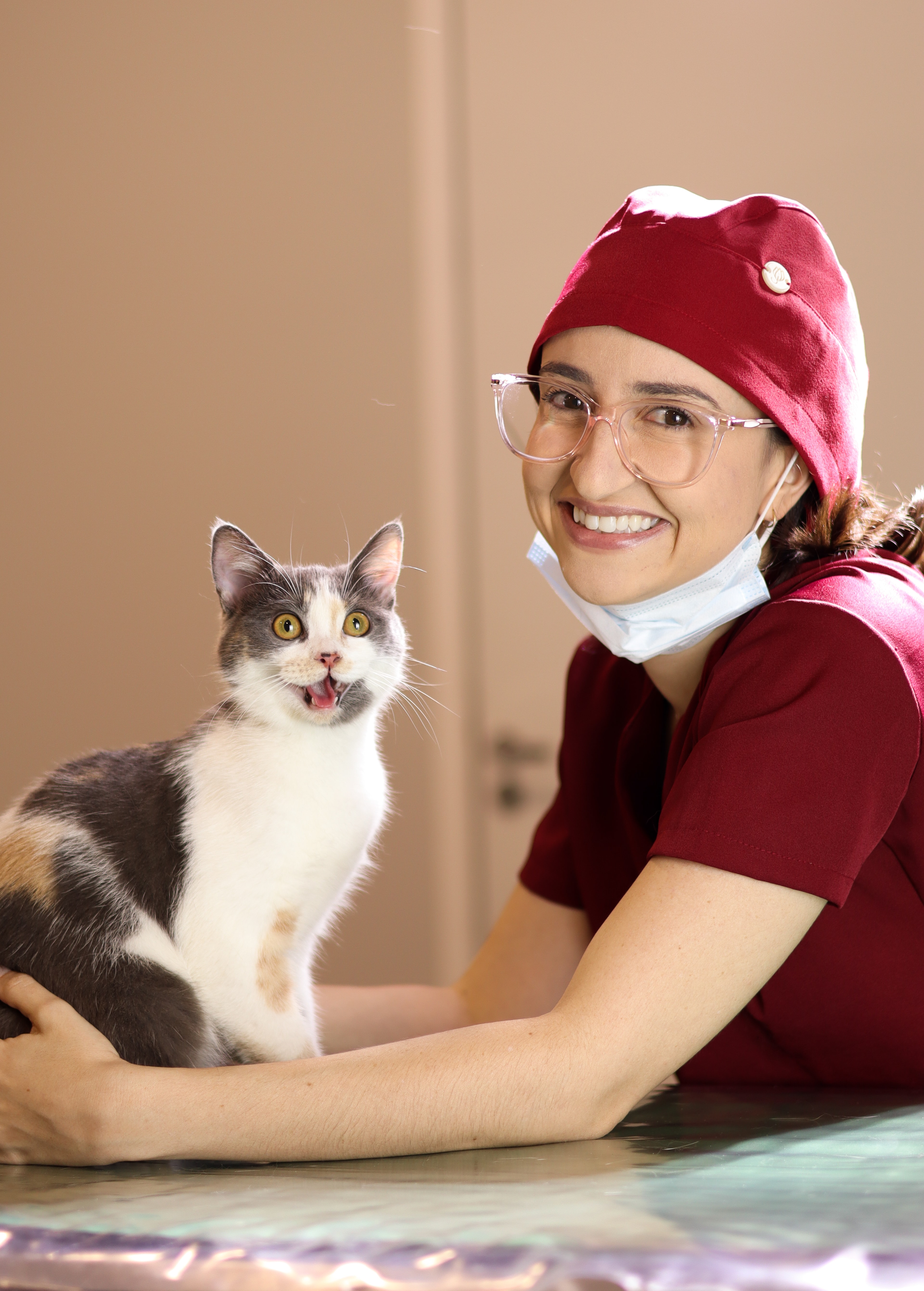 Vanessa sorrindo ao lado de uma gata durante o atendimento veterinário